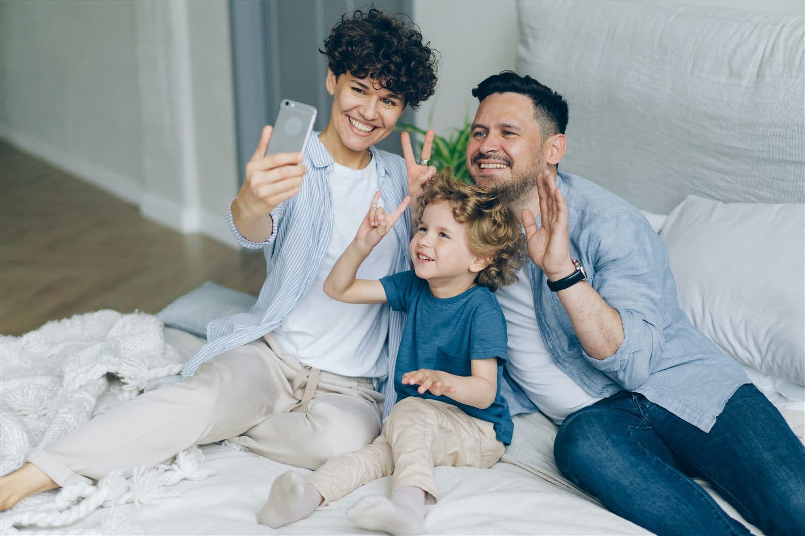 Une famille prenant un égoportrait ensemble lors d'un appel vidéo à la maison